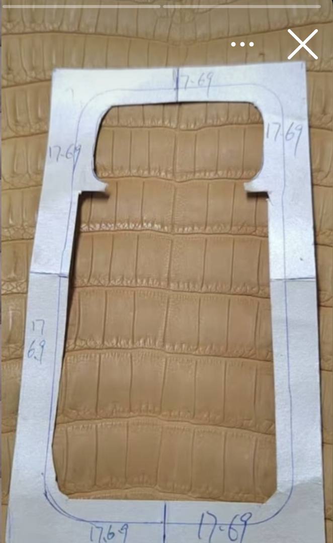 Cutting template over tan crocodile hide