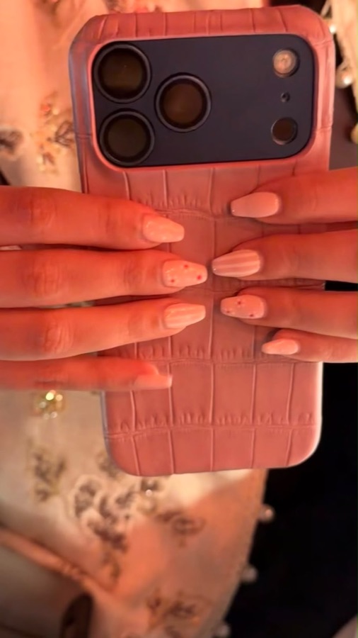 A blush pink crocodile Croco Lab case held in hand